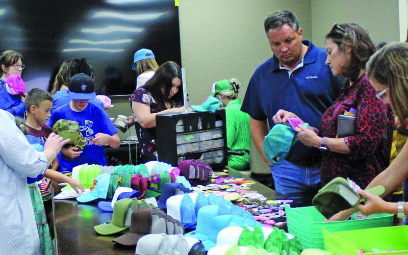 Sentinel Photo/Jessica Shepard Matagorda Regional Medical Center Foundation hosted a "Trucker Hat Bar" fundraiser last Thursday, July 13. Hats in adult and youth sizes were customized with a variety of patches, pins, and chains with a portion of the proceeds benefitting the foundation. The foundation also sold tickets to its upcoming fall fundraiser "Pulse" to upgrade the hospital's "Cardiac Patient Monitoring System".