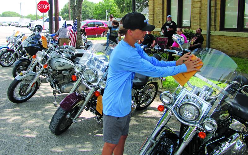 A participant in last weekend’s Hotel Blessing car show places a registration on a motorcycle windshield at Blessing Saturday, July 15. Sentinel Photo/Mike Reddell
