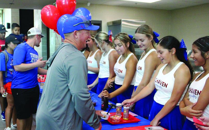 Tidehaven coach Bill Russell gets an extra scoop of sprinkles on his ice cream during the Tidehaven Athletic Booster Club’s ice cream social last week. Sentinel Photo Jessica Shepard