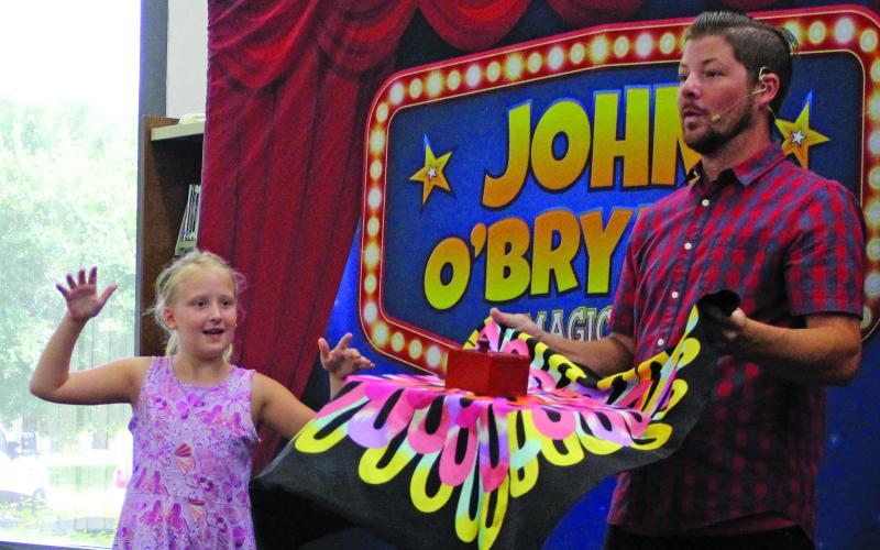 Magician John O'Bryant shows off his favorite trick - the levitating table during Bay City Public Library's last summer program  Aug. 1. O'Bryant also stayed after his show to teach the summer's top readers some simple magic tricks. Sentinel Photo/Jessica Shepard