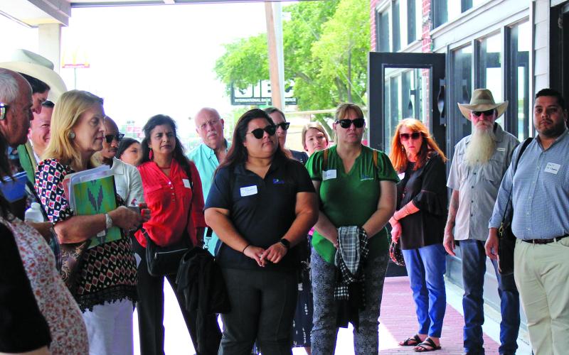 Sentinel Photo/Jessica Shepard Bay City Main Street Program Director Tina Isreal, right, explains how almost every downtown business has used the program’s façade grants to beautiful or renovate their building’s exteriors. Israel’s downtown walking tour was the capstone of the Houston-Galveston Area Council’s “Downtown Roundtable” July 25.