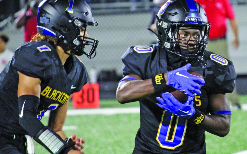 Sentinel Photo/Mike Reddell Blackcat quarterback Alex Estrada, left, hands off to running back Jada Andrews.