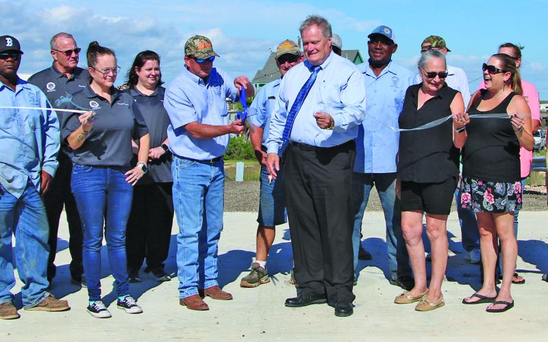 Sentinel Photo/Mike Reddell Precinct 2 hosted a grand opening for the new bridge on County Road 201 in Sargent last week. In the center, Precinct 2 Commissioner Mike Estlinbaum (with cap) and County Judge Bobby Seiferman cut the ribbon.