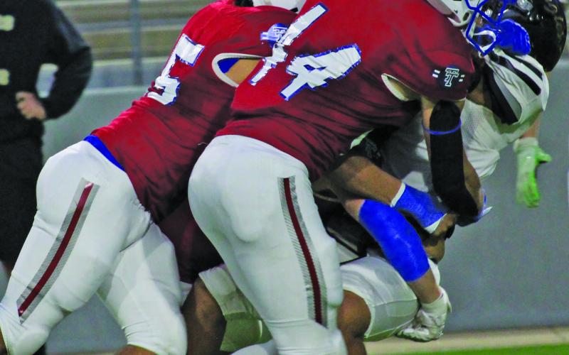 Sentinel Photo/Mike Reddell Justin Griffith (44) is joined by other Tidehaven tacklers in stopping a Rogers running play.