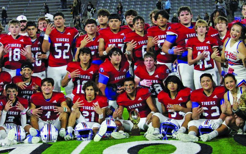 Photo by Anna Hernandez Tidehaven players, coaches, cheerleaders and trainers gather for a group photo of the Tigers winning the regional semi-finals trophy.