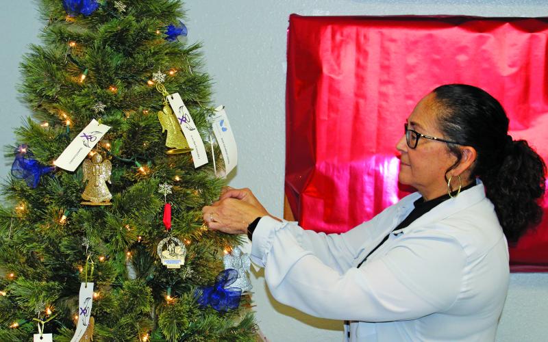 Sentinel Photo/Jessica Shepard Bay City Police Chief Christella Rodriguez helped place ornaments on this year's annual "Tree of Angels" during a ceremony Wednesday, Dec. 6. The tree is on display now in the BCPD lobby.