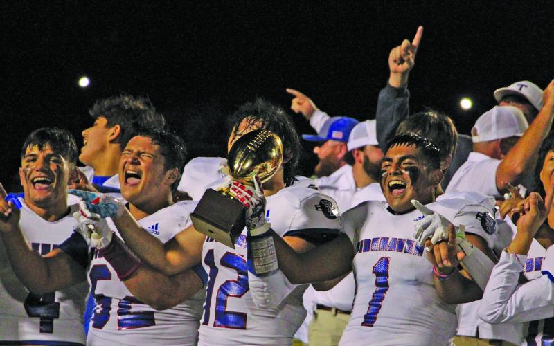 Sentinel Photo/Mike Reddell Tigers celebrate quarterfinal victory, with trophy, over Poth.