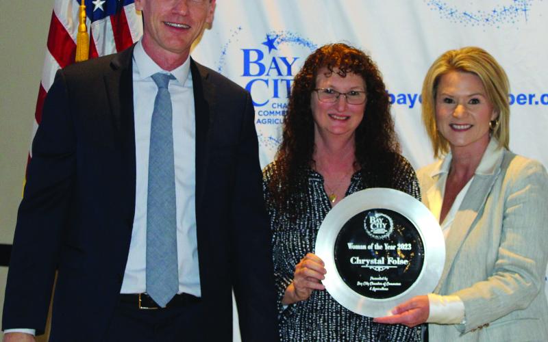 Sentinel Photo/Jessica Shepard Chrystal Folse, center, accepts the Woman of the Year Award from Matt Gullett, the 2024 chamber board chairman; and Danyel Biggerstaff, who was closing out her term as board chair.