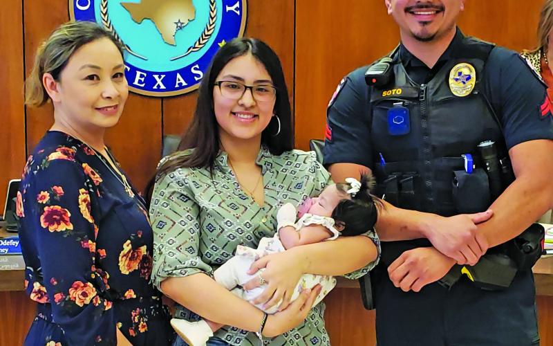 Sentinel Photo/Jessica Shepard Bay City PD's Corporal Jose Soto received an award and recognition for performing life-saving CPR on infant Emery Lazo at the City Council on Tuesday, April 9. Soto, right is joined by Emery Lazo and her family at the meeting.