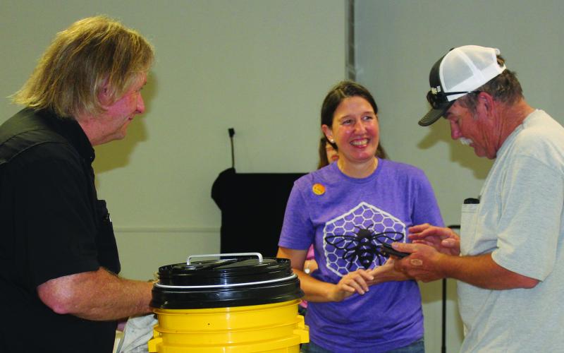 Sentinel Photo/Jessica Shepard Bee Love TX owner Cheryl Wilson, center, discusses various types of equipment needed for apiaries and beekeeping after her "Beekeeping 101 workshop" last week. Wilson partnered with the Matagorda County Texas A&amp;M AgriLife Extension Office to host the event April 30.