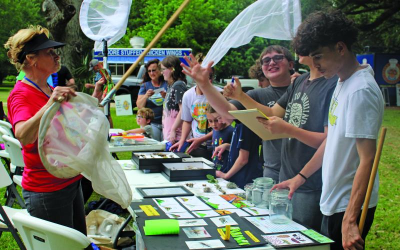 Sentinel Photo/Jessica Shepard Retired biology teacher and Matagorda County Birding Nature Center volunteer Diana Frankson, left, hands out nets for high school students to catch bugs during the center's annual "Full Moon Food Truck Festival" on Saturday, April 27. Bay City High School students need the bugs for their biology class project.