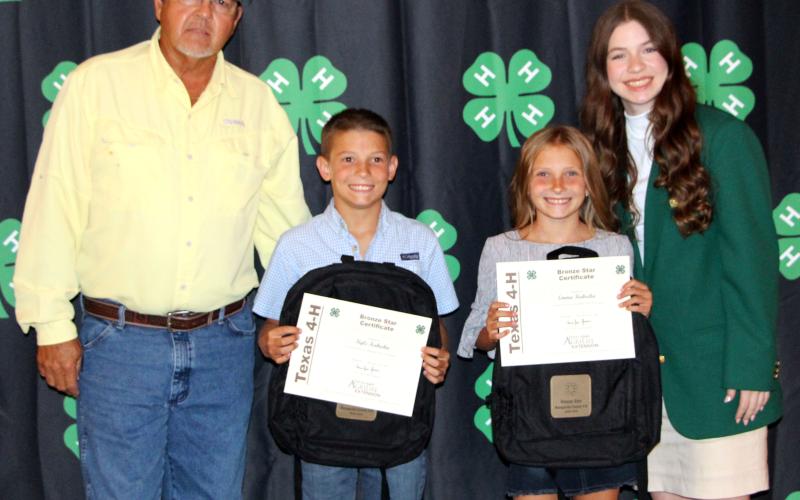 Sentinel Photo/Jessica Shepard Bronze Star awards were given to Kyle Kubecka and Emma Kubecka, above with Precinct 4 Commissioner Bubba Frick, left, and 4-H Ambassador Scollie Saha, right.