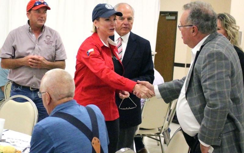 Sentinel Photo/Jessica Shepard Land Commissioner Dawn Buckingham shakes hands with MCEDC Executive Director Mike Ferdinand, while Precinct 2 Commissioner Mike Estlinbaum, left, and Chamber President Mitch Thames look on.