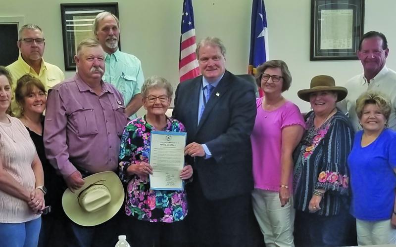 Sentinel Photo/Mike Reddell Commissioners Court proclaimed Monday, July 15, as Helen Feldhousen Day in Blessing. Miss Helen, center with proclamation from County Judge Bobby Seiferman, was joined by family and friends at the court session. She started as kitchen support in 1969 and became sole proprietor in 1977 and continued through 2024.