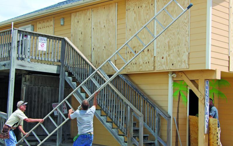 Sentinel Photo/Mike Reddell Workers finish boarding up the Waterfront Restaurant in Matagorda Harbor Sunday, July 7, in preparation for the arrival of Beryl.