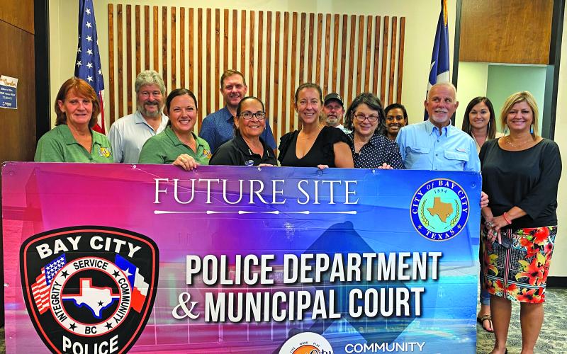 Sentinel Photo/Jessica Shepard Bay City Police Chief Christella Rodriguez and Bay City Community Development Corporation Executive Director Jessica Russell posed with the BCCDC board to celebrate the community partnership between the entities Monday afternoon. The partnership will help fund the creation of a new public safety facility.