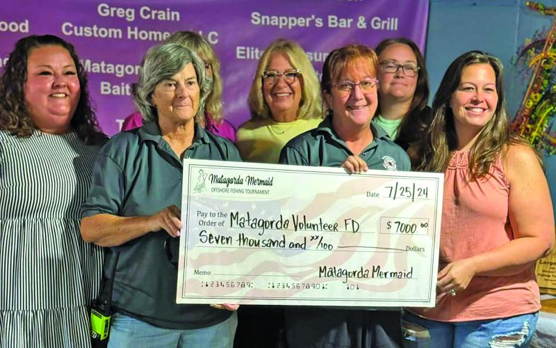 Courtesy photo Ashley Lubbers, Laura Marshall, Gail Krejki, and Courtney Perrosky with Matagorda Mermaid Tournament donated funds to the Matagorda Fire &amp; Rescue (pictured), Matagorda Historical Society, Matagorda United Methodist Church Food Pantry, and Latchkey Program on July 25.