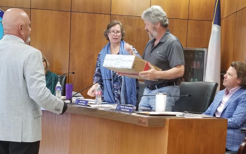 Sentinel Photo/Mike Reddell Bay City Police Narcotics Division Head Sgt. Joe Bruno, left, hands a shipment box with illegal drugs to, from left, Mayor Pro Tem Becca Sitz, and Councilmen Jim Folse and Bradley Westmoreland at a recent council meeting.