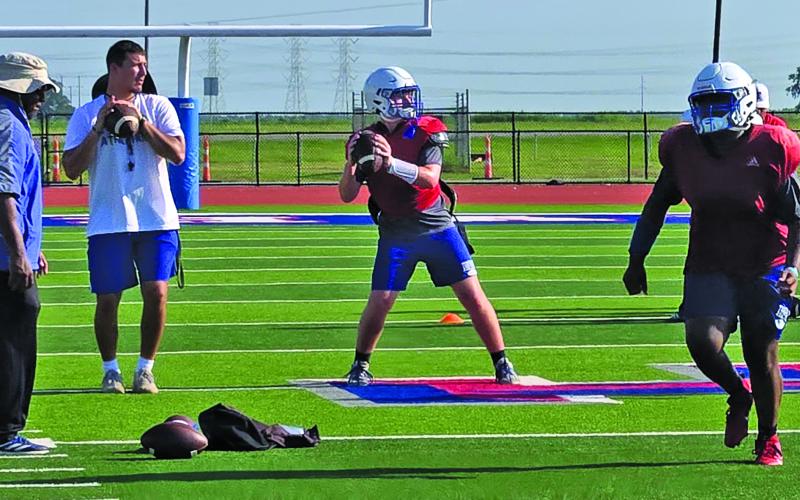 Sentinel photo/MaLinda Reddell New Tiger coach Bryce Galvan helps guide the Tidehaven passing drill.