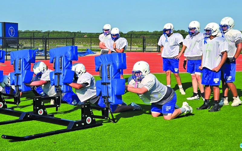 A Tidehaven coach watches players technique on the blocking sled. Sentinel photo/ MaLinda Reddell