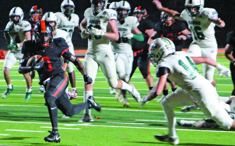 Sentinel Photo/Jessica Shepard Van Vleck running back Corey Austin (0) outruns Woodlands defenders in the Leopards homecoming game last Friday.