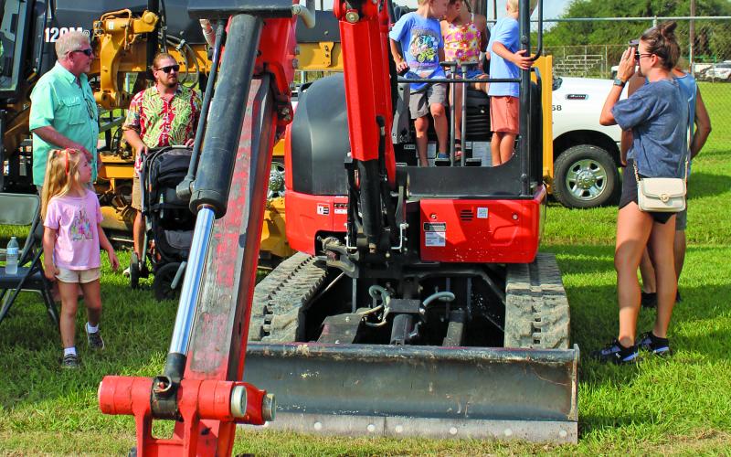 Sentinel Photo/MaLinda Reddell Children were temporarily behind the controls at an excavator under the watchful eyes of their parents at Touch-A-Truck Saturday at the Sports Complex on Saturday, Sept. 14. The fifth annual event was hosted by the Bay City Parks and Recreation Department.