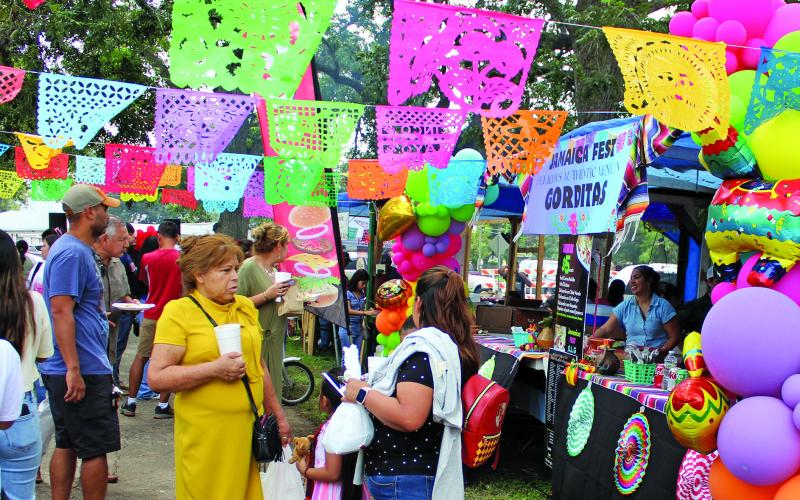 Sentinel Photo/Jessica Shepard Colorful decorations and tantalizing scents drew attendees to various food vendors at Our Lady of Guadalupe Church's annual "Parish Jamaica" event on Sunday, Sept. 15. The event also featured carnival games, live entertainment, a cake walk, and more.