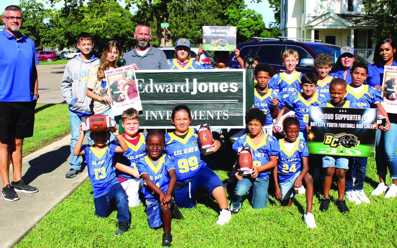 Sentinel Photo/Jessica Shepard James Scardami's Edward Jones Office and Marine Corps Toys for Tots recently donated the first batch of Bay City Youth Football and Cheer "Lil Cats" game balls for the season. Along with several Lil Cats team members and parents are, from left, Bay City Youth Football and Cheer President Israel Ochoa, Connor Scardami, Emily Scardami, and James Scardami.