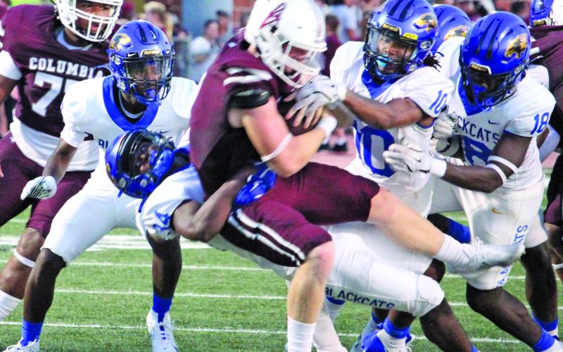 Sentinel Photo/Mike Reddell Bay City senior defensive end Cameron Spencer (34) pulls down a Roughneck running with Davont’A Harris (10) and Trevell Wells (18) moving in to help.