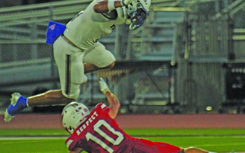 Photo by Anna Hernandez Tidehaven’s Boogie Galvan (4) hurtles over Palacios defender Noah West (10).