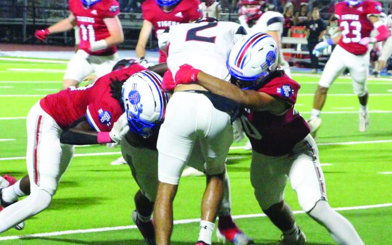 Sentinel Photo/Jessica Shepard Two Tidehaven tacklers, Mathew Riddick on the left and Eli Daily on the right, converge on a Brazos running back.