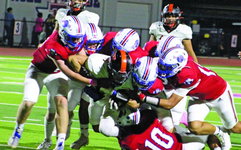 Sentinel Photo/Jessica Shepard Above left, Tidehaven defenders converge on Van Vleeck star running back Corey Austin.