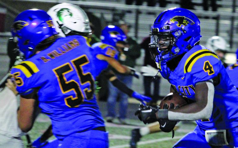 Sentinel Photo/Mike Reddell Sophomore running back Aiden Williams (4) follows the blocking of junior tackle Benjamin Williams (55) against Canyon Lake.