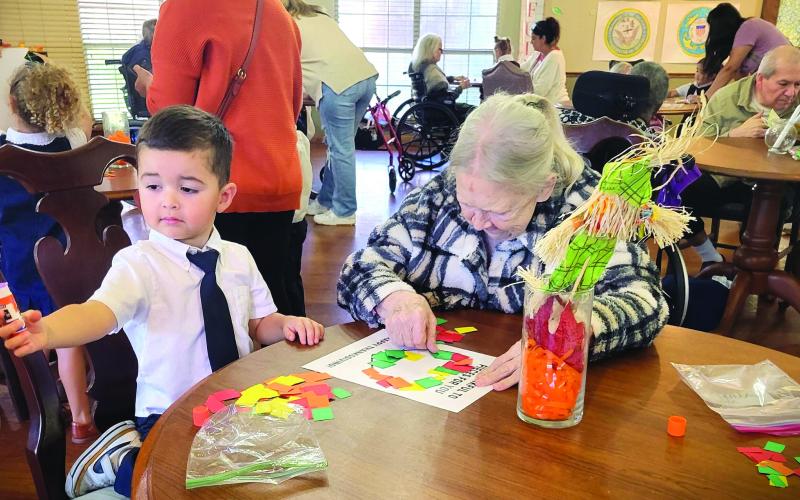 Holy Cross Catholic School photo During Community Helpers Week, Holy Cross Catholic School's PreK-3 and PreK-4 students visited the Colonial Living Nursing and Rehabilitation Center as part of their giving back to the community. The students entertained with the song, "Here I Am To Worship." They also colored with residents and gave them their artwork.