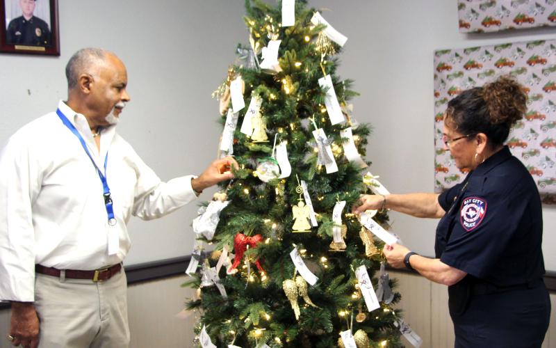 Mayor Robert Nelson and Police Chief, Christella  Rodriguez placing tributes on the Tree of Anges at Bay City Police Station Thursday, Dec 5. Sentinel photo/Jessica Shepard