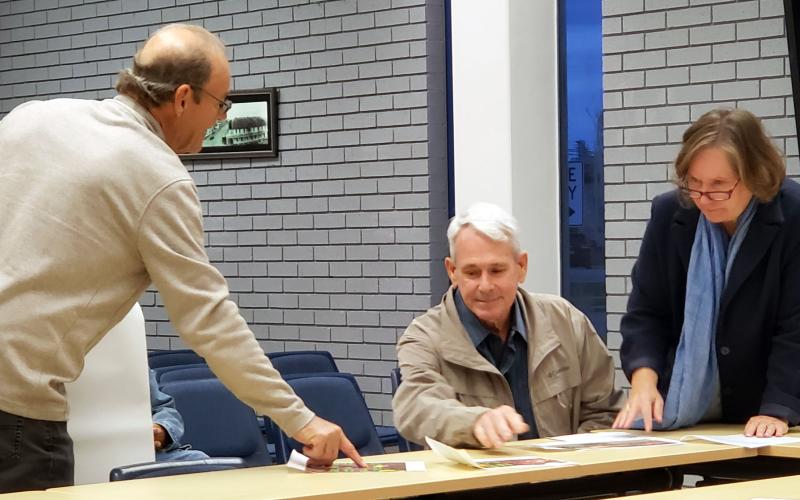 Sentinel photo/Jessica Shepard City Variance Committee members Bill Frontz and Becca Sitz, right, review artist Tom DeGroot's, left revised sign for the Neon Moon during a meeting Friday, Dec. 6.