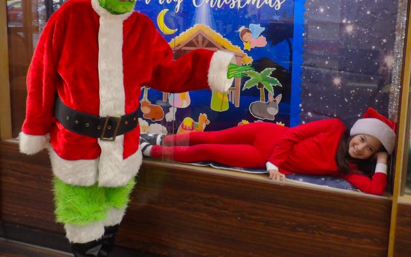 Holy Cross photo Holy Cross Catholic School had  an 'Elf on a Shelf'  Wednesday, Dec 11. Some students walked by unaware, while others giggled with joy. On Grinch Day, Dec. 12, she was found behind glass in the school's display cabinet by the Grinch himself.