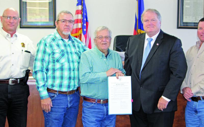 Sentinel Photo/Jessica Shepard Commissioners approved a resolution honoring outgoing Sheriff Frank “Skipper” Osborne, center, for his service to the county Monday morning. With Osborne are, from left: Sheriff Rick DeLeon, Precinct 4 Commissioner Bubba Frick, County Judge Bobby Seiferman, and Precinct 2 Commissioner Mike Estlinbaum.