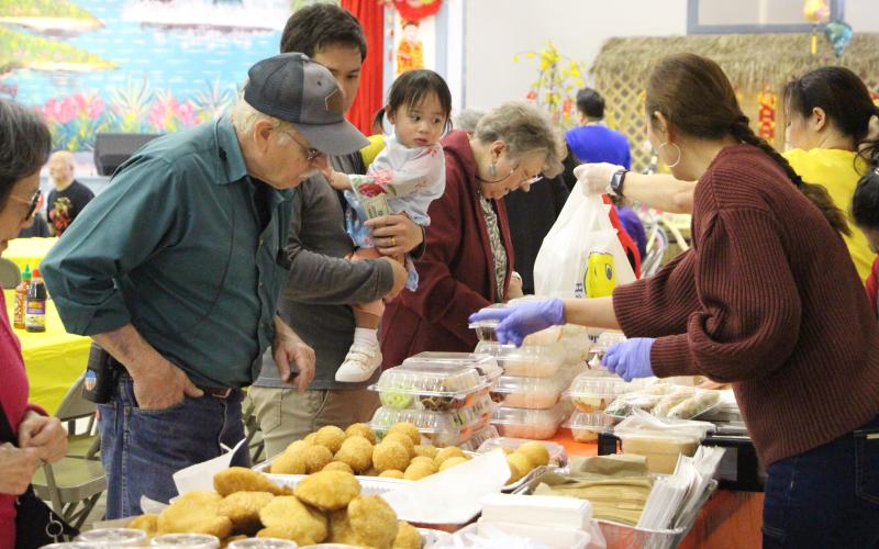 Sentinel Photo/Jessica Shepard Several Palacios residents pick between lunch fare, desserts, and drinks at the Our Lady of La Vang Catholic Church.
