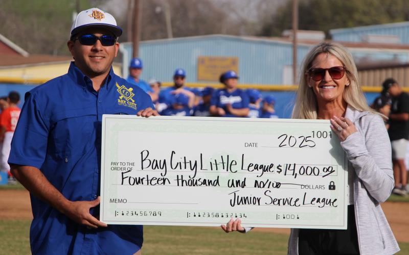 Sentinel Photo/Jessica Shepard Bay City Little League President James Cadenas, left, accepts a $14,000 donation from the Junior Service League of Bay City Saturday, March 15.