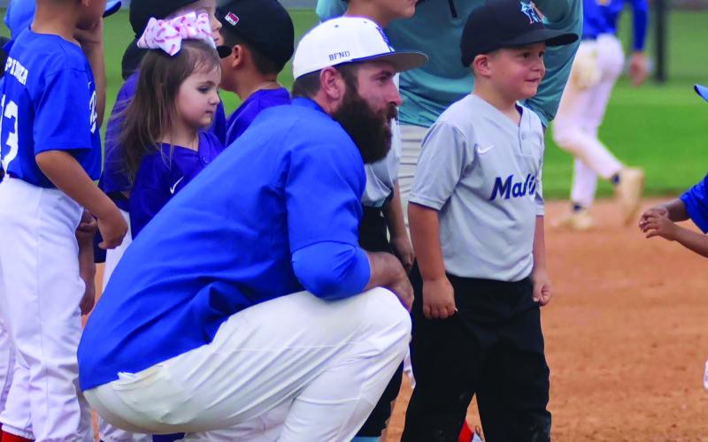 BCISD photo Bay City High School Baseball Coach Jared Hoelscher talks to a Little Leaguer when the Blackcats hosted Little League at a recent game.