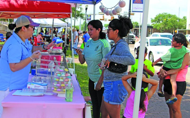 Sentinel Photo/Jessica Shepard Local bakery vendor "Kate's Delights" macaron cookies drew a crowd of customers during the Downtown Bay City Market Days event last Saturday.
