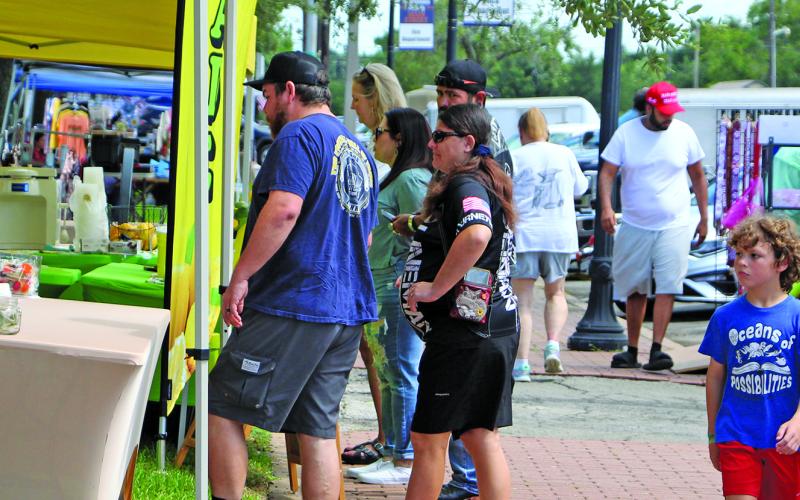 Sentinel Photo/Jessica Shepard A colorful array of vendors enticed customers to brave the heat and rain during Downtown Bay City Market Days on Saturday, July 26. The monthly event had food trucks, homemade wares, and everything in between for visitors and residents.