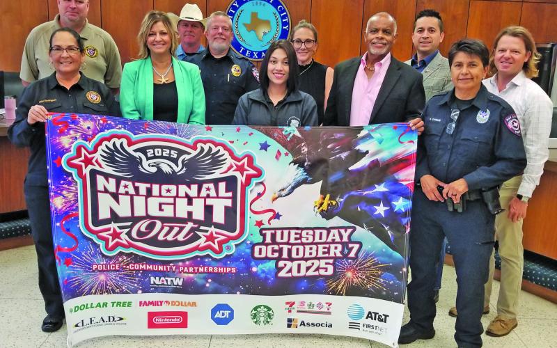 Sentinel Photo/Mike Reddell City officials and city council members join Bay City Police Department officers in showing off a promotional banner for the 2026 National Night Out event Tuesday, Oct. 7. the police-community partnership helps develop bonds between Bay City residents and police officers.