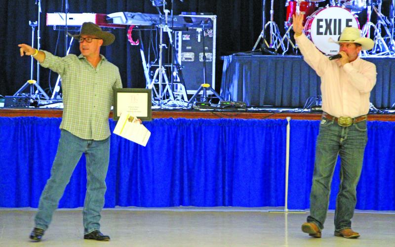 Sentinel Photo/Jessica Shepard Bay City Rotary Club's Jason Childers, left, helps auctioneer Clint Hewitt, right, spot bidders at the "Annual Rotary Summer Concert" last Saturday. Items auctioned included a meal cooked by Tine Keen, a mystery cooler, and men's and women's cowboy hats autographed by concert headliner "Exile."