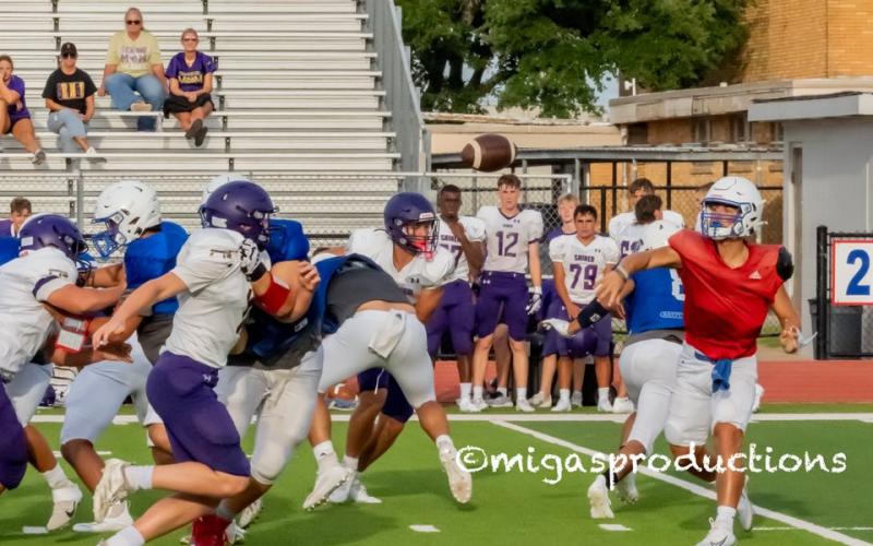 Migasproductions The Tidehaven quarterbac throws a pass against the oncoming Shiner defense at last week’s scrimmage.