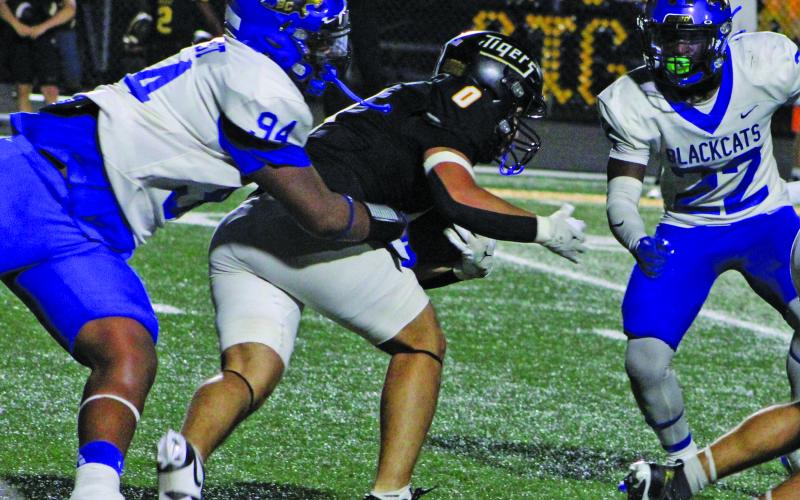 Sentinel Photo/Mike Reddell Junior nose guard Jaevan West (94) grabs a Sealy running back, while junior linebacker James Copeland (22) moves in to assist.