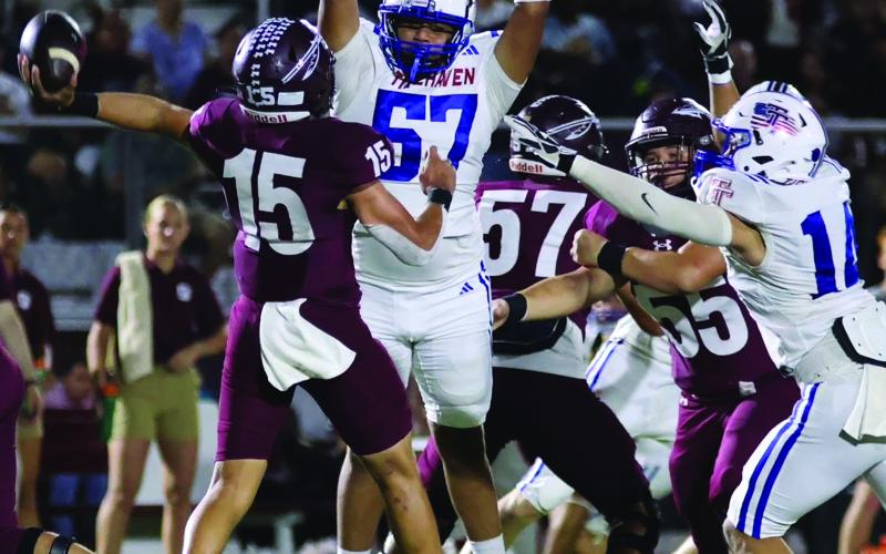 LeDarion Stone/Live in the Moment Photography Tidehaven defenders Jayden Torres (57) and Hayden McCarver make life uncomfortable for the Ganado quarterback.