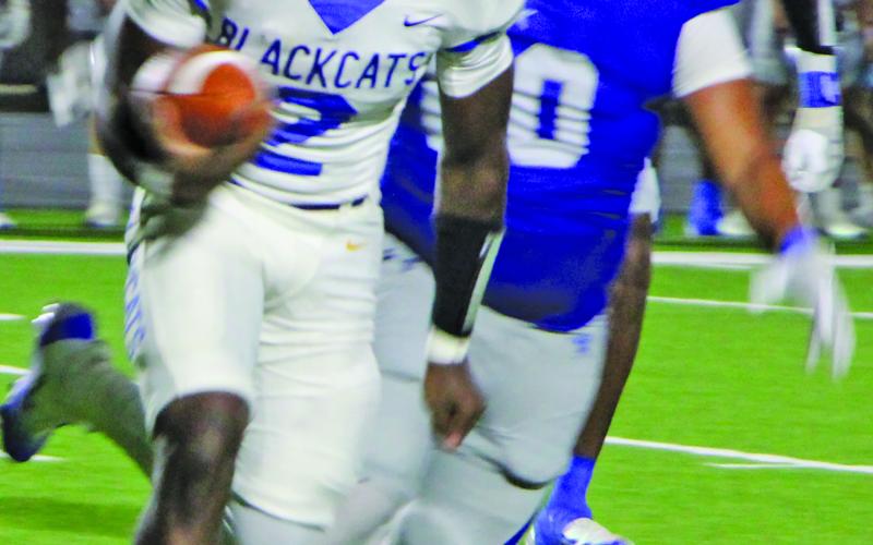 Sentinel Photo/Mike Reddell Blackcat junior quarterback Keimarion Williams (2) looks ahead for a gain with an Edna defender close behind.