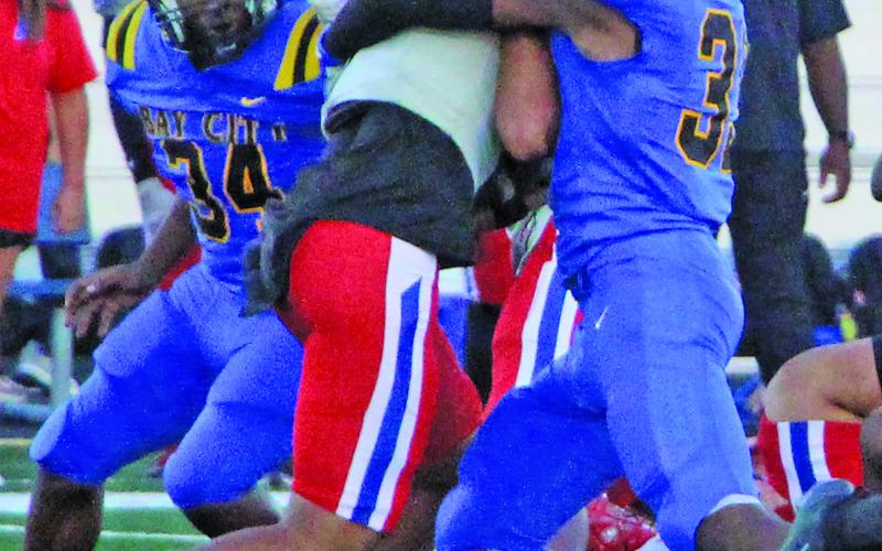 Sentinel Photo/Mike Reddell Blackcat defensive end Jordan O’Neal (33) wraps up a Brazosport Exporter, while freshman defensive tackle Kelon Ellis (34) moves in to help.